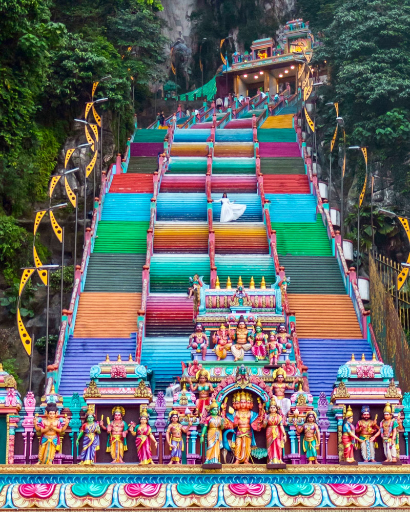 A girl in white standing at the stairs of Batu caves
