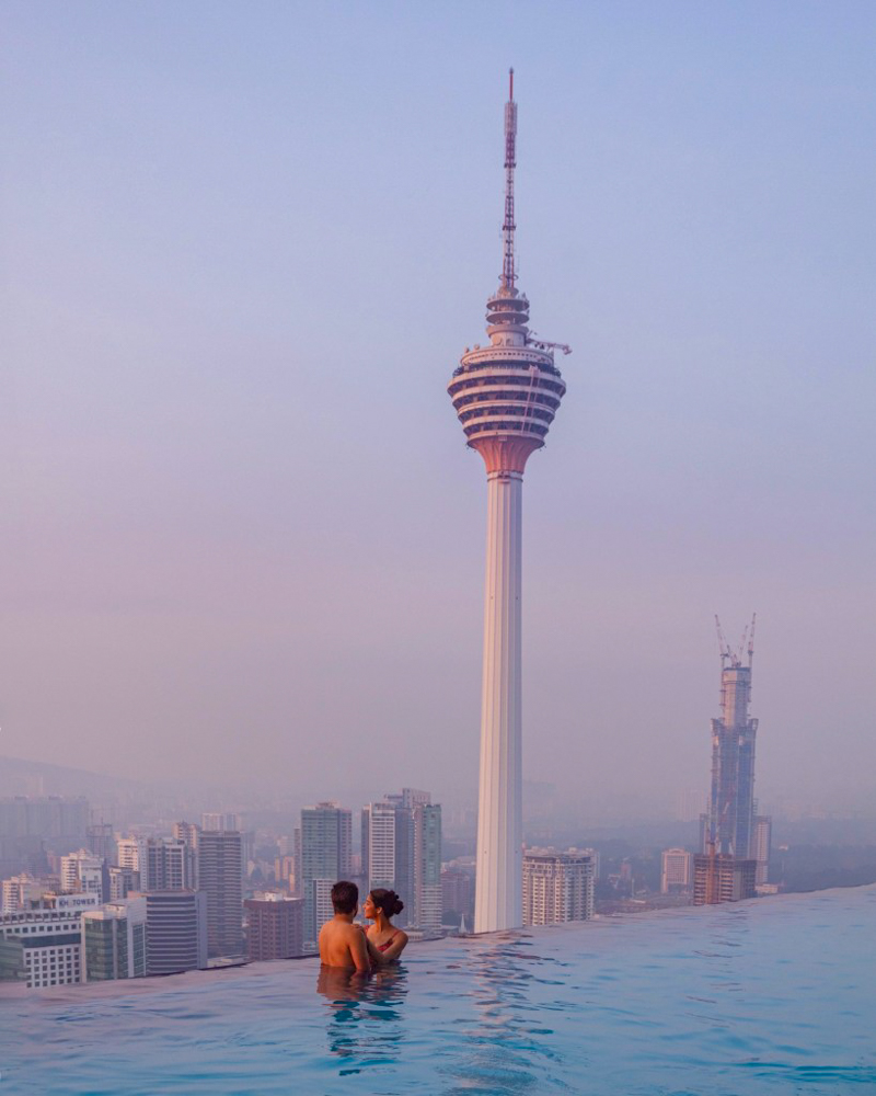 A couple in the infinity pool at face suites