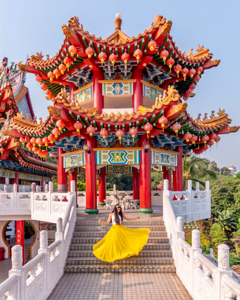 A girl in yellow skirt twirling at the stairs of Thean Hou temple