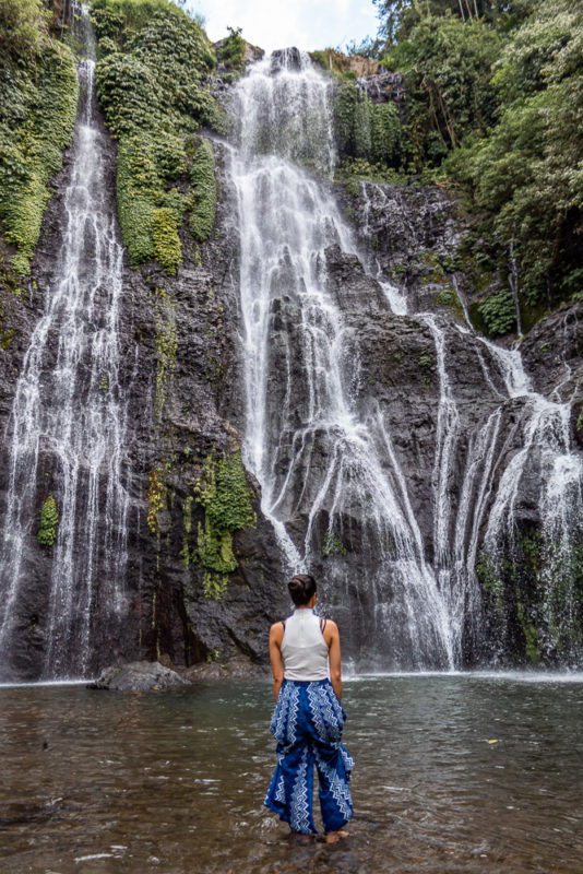 A girl standing in front of Banyumala waterfall in munduk bali