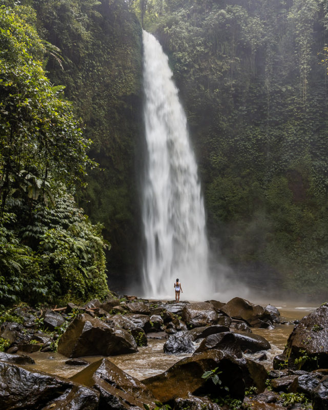 A girl standing in front of nungnung waterfall in munduk north bali