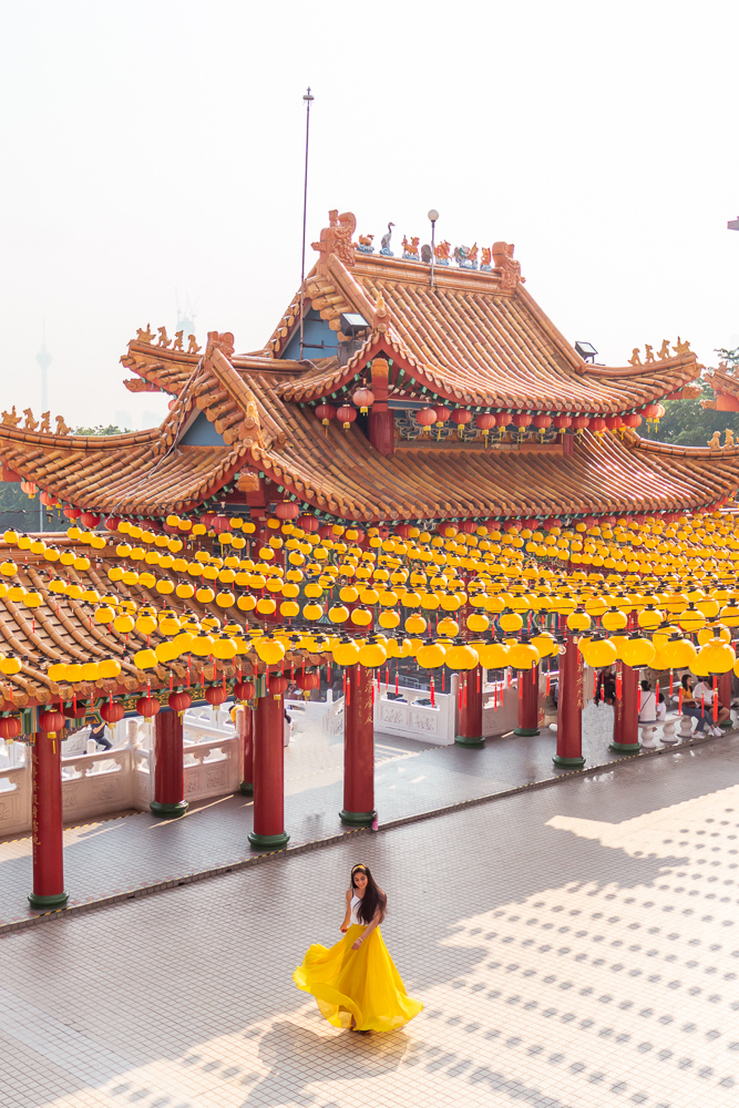 A girl in yellow skirt twirling during 3 day Kuala lumpur itinerary malaysia