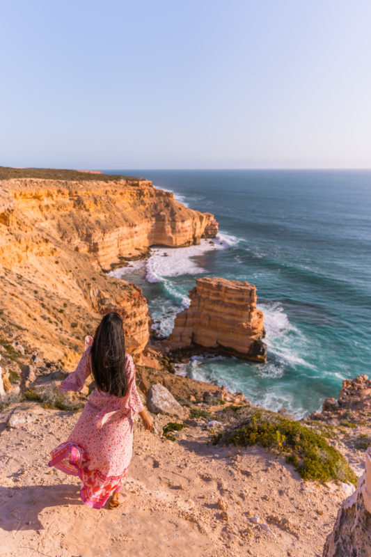 A girl in Pink Dress looking at Island Rock during Perth to Kalbarri Road trip