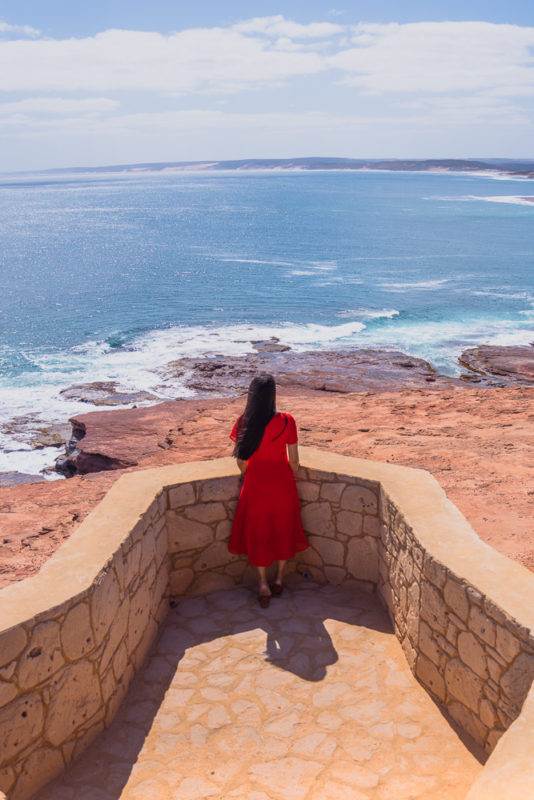 A girl in red dress standing at the lookout of red bluff beach - Perth to Kalbarri road trip