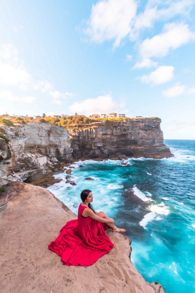A girl in red dress staring at the views of Diamond bay in sydney