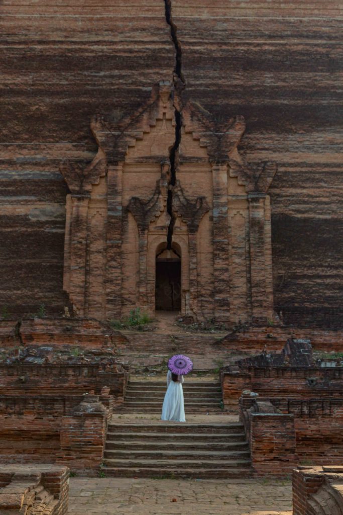 A girl in white dress standing in front of cracked pagoda in Mandalay