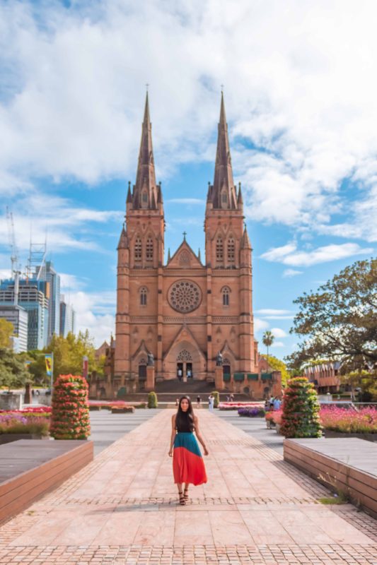 A girl in orange skirt posing at St. Mary's Cathedral in Sydney
