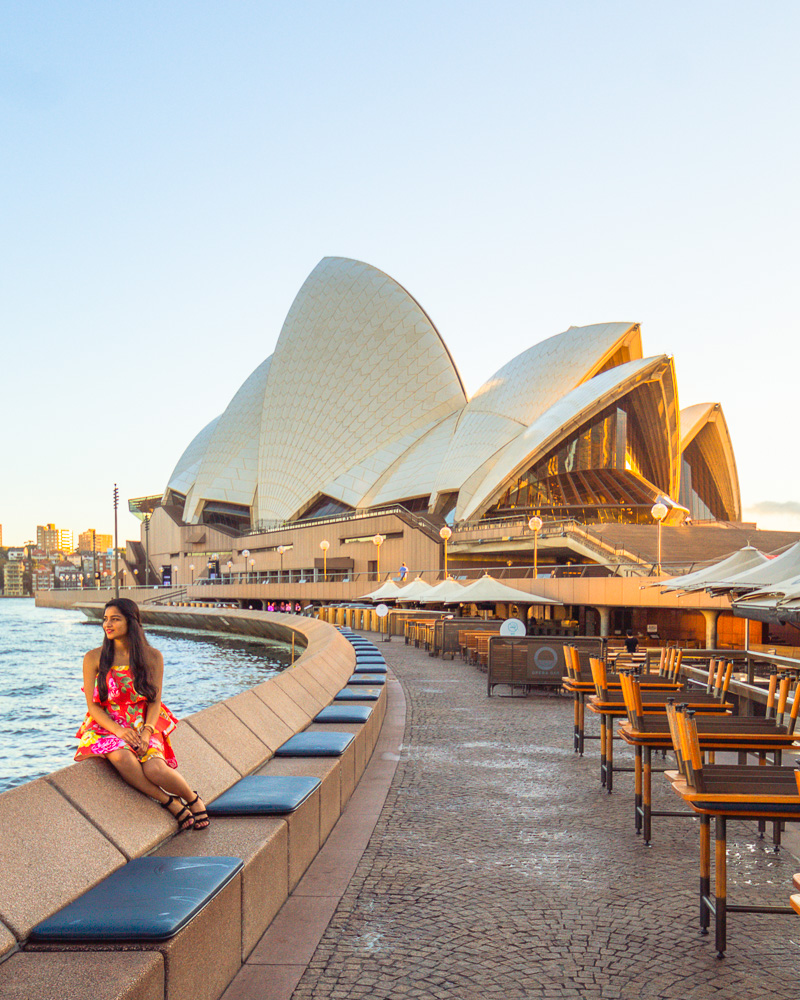 A girl in red dress posing at Sydney opera house at sunrise during 3 days in sydney