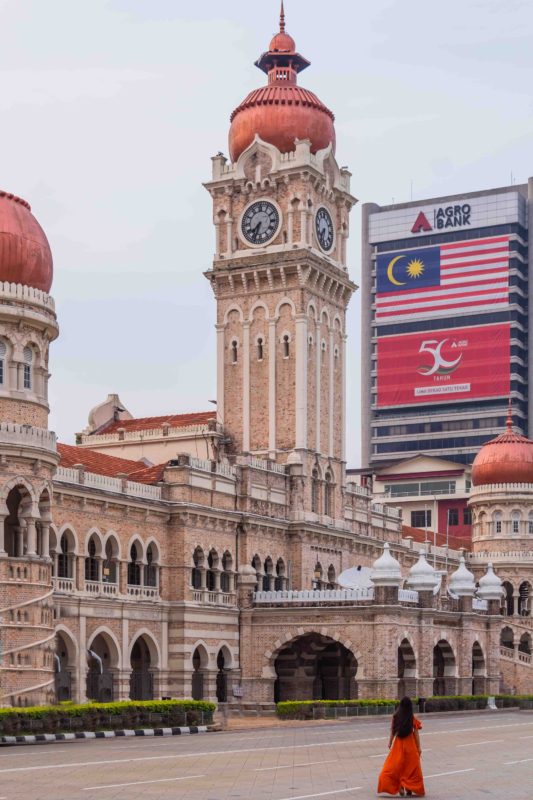 A girl in orange dress in front of Sultan Abdul samad Building in Kuala Lumpur