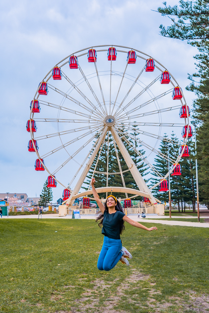 A girl happily jumping at Esplanade Park in Fremantle Australia