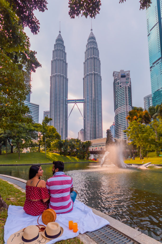 A couple enjoying the view of Petronas from KLCC park