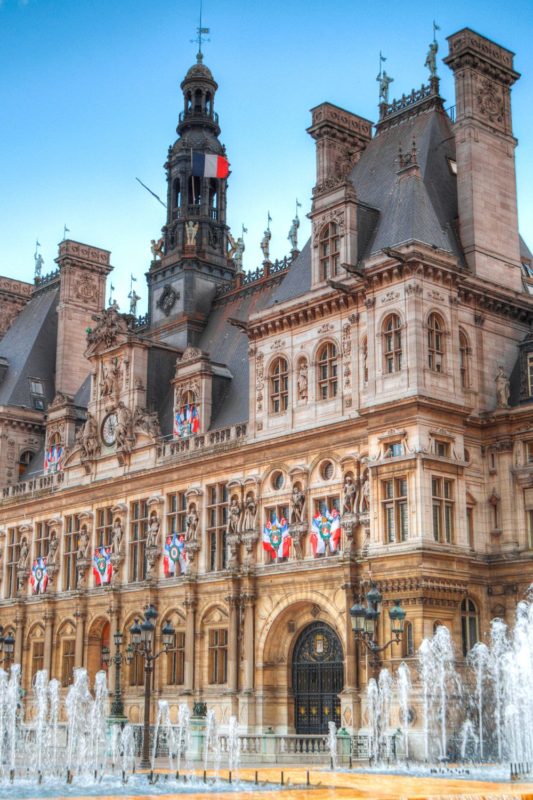 Impressive city hall, Hotel de Ville in Paris with the fountains in front of it.